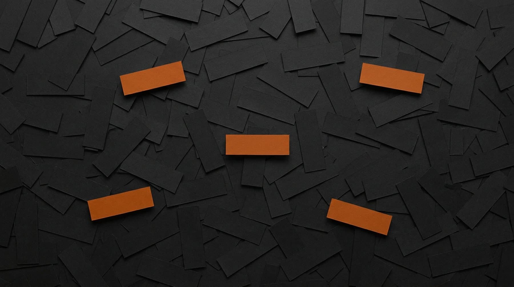A field of hundreds of dark paper slips with a handful of orange ones standing out among them